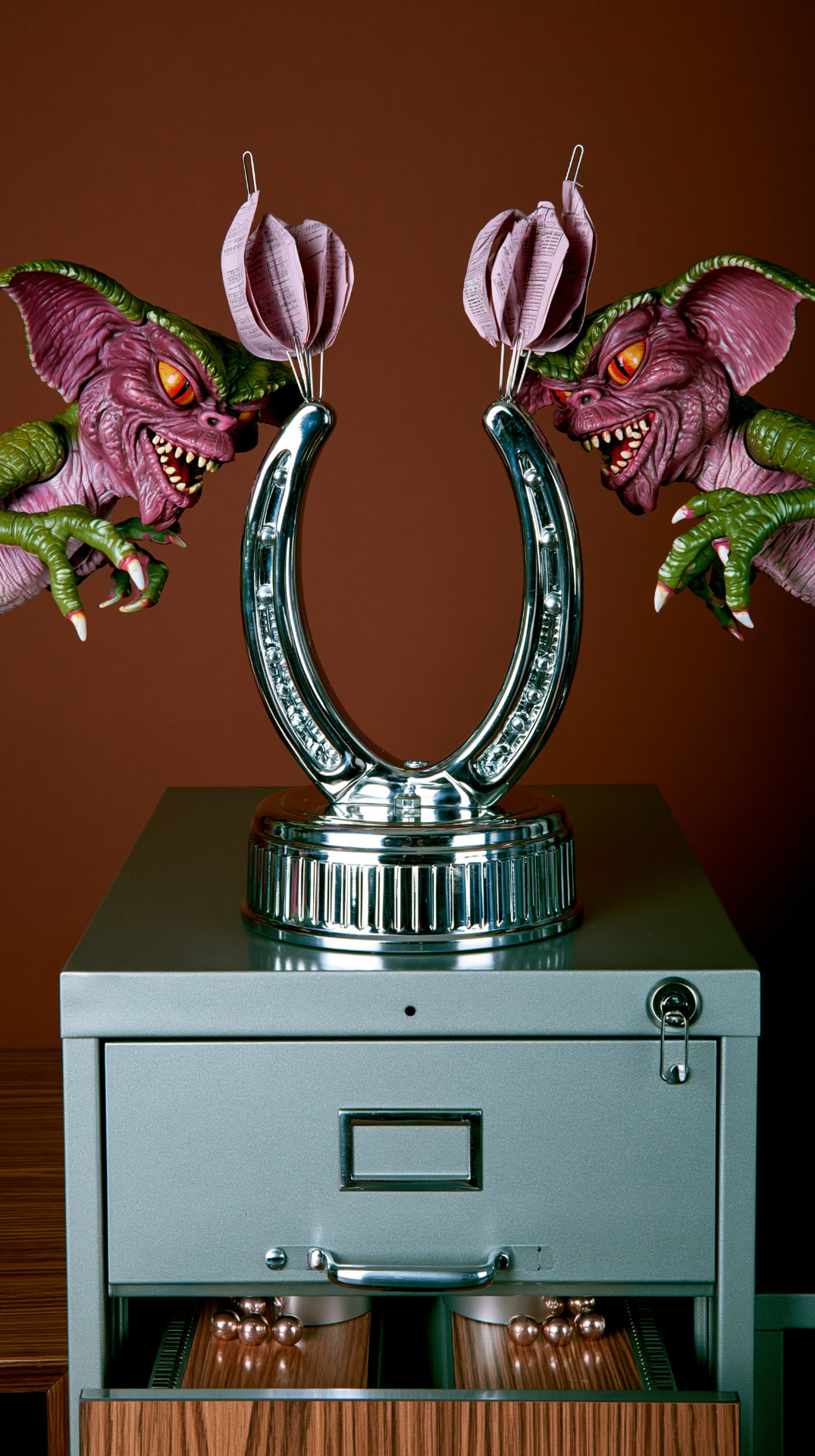 Two identical figures at opposite ends of a single chrome horseshoe, facing each other.